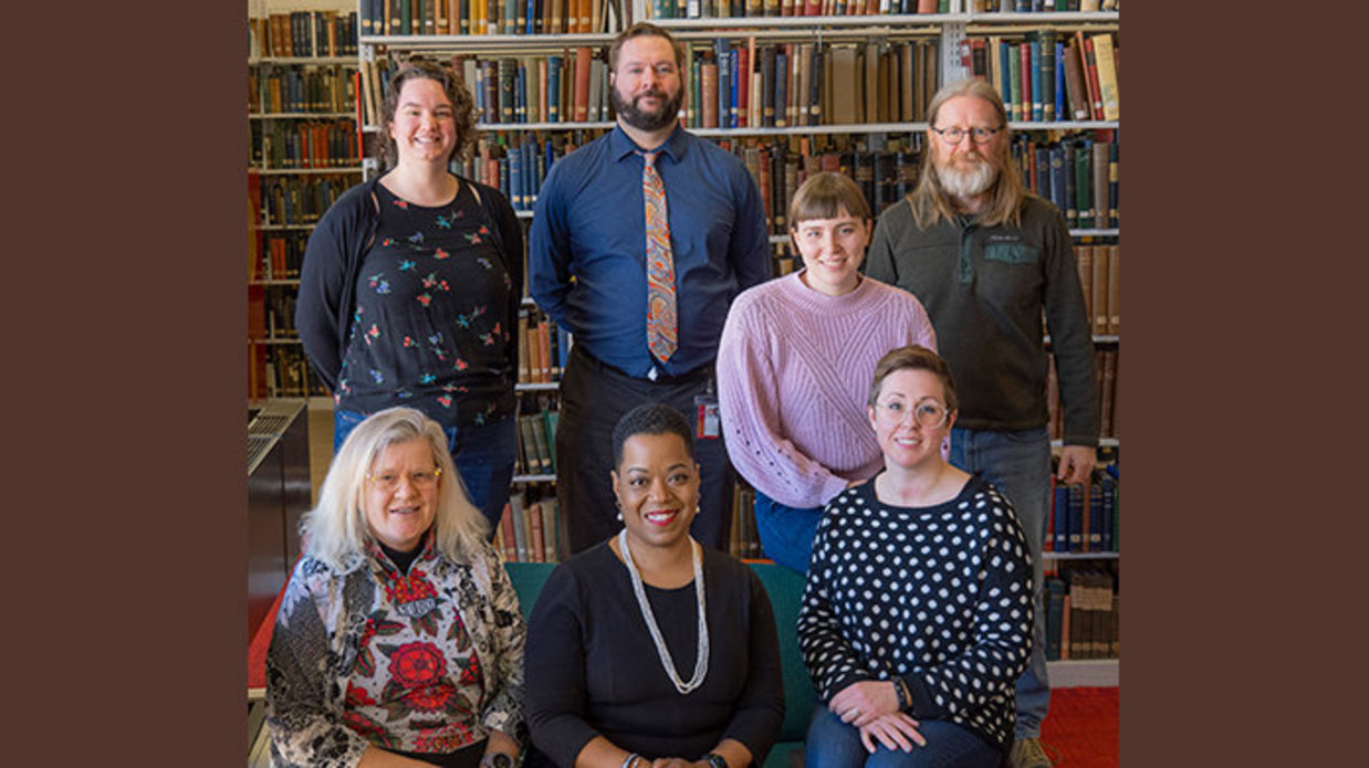 ACE Team arranged for a group photo in front of shelves of books.