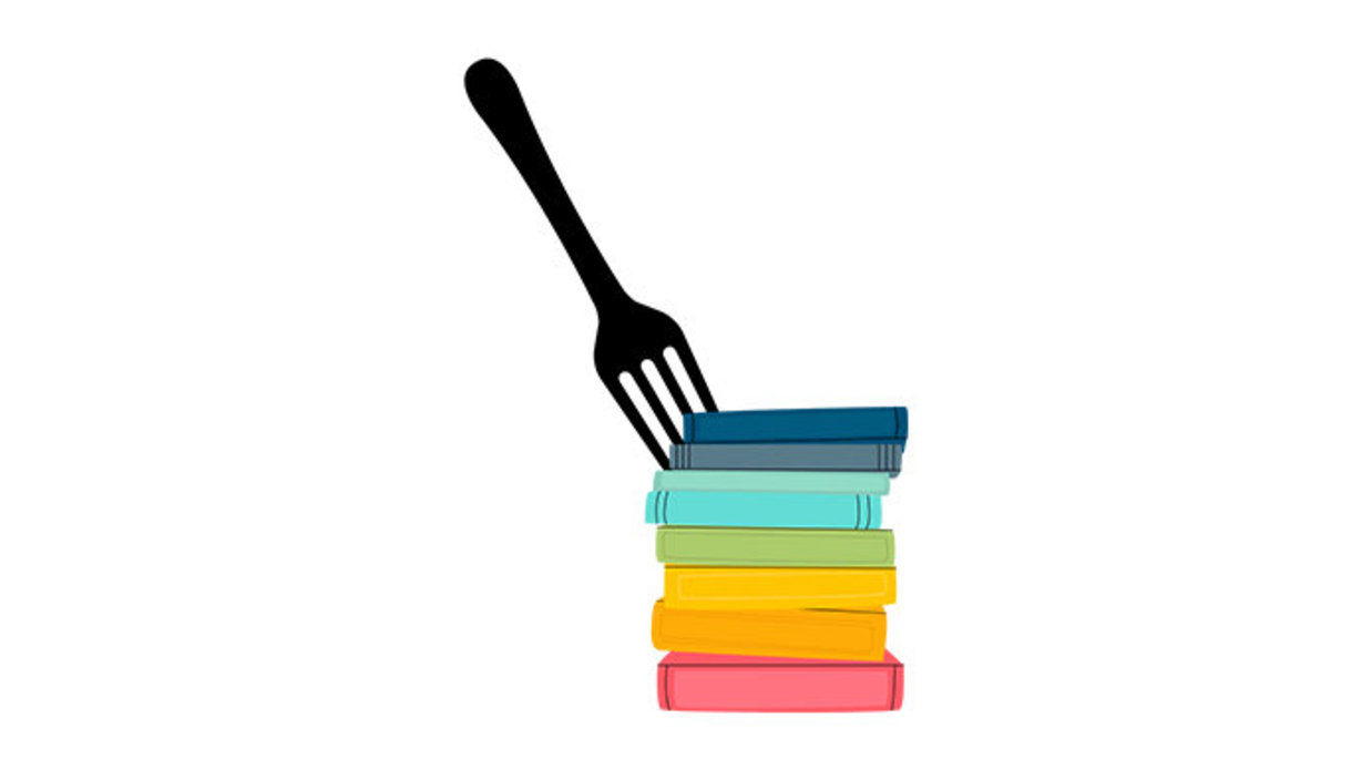 Fork sticking out of multicolored stack of books.