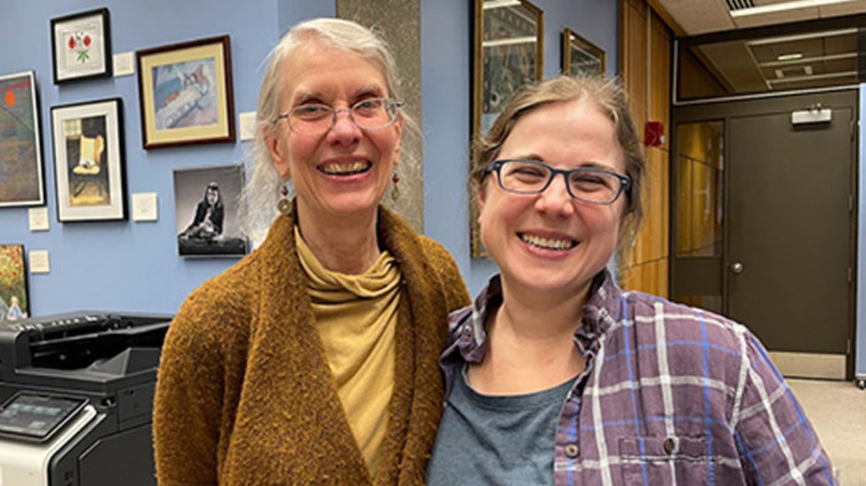 Ellen Broadwell with Ashley Maiville, both smiling, walls behind them with various art hung up.