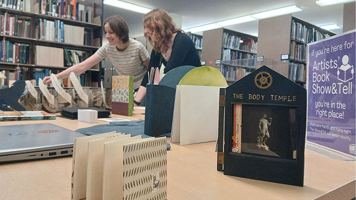 Students browsing a selection of artists' books from the Clarence Ward Art Library's collection