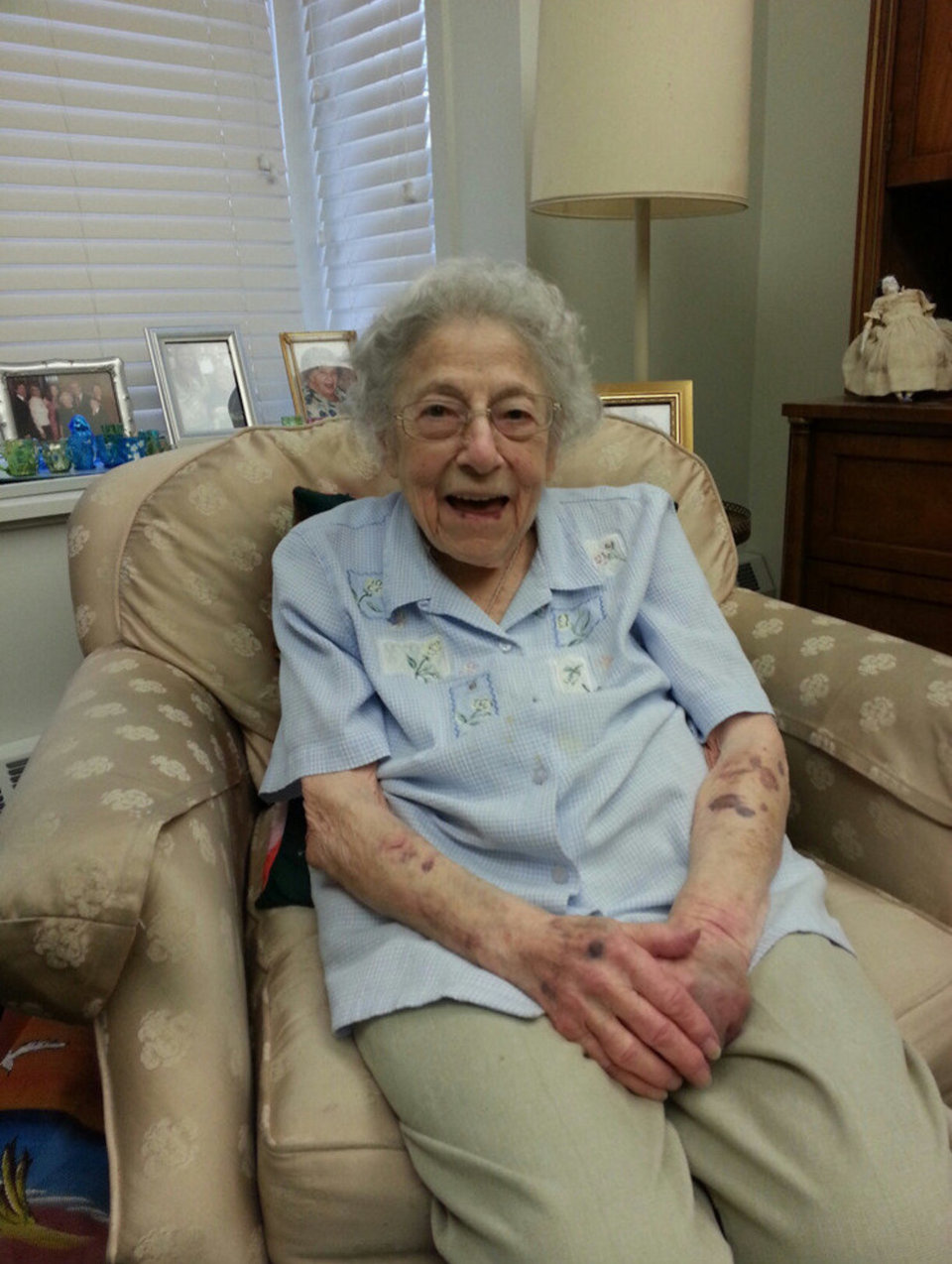 Esther Hunt sitting in an armchair and smiling, photo.
